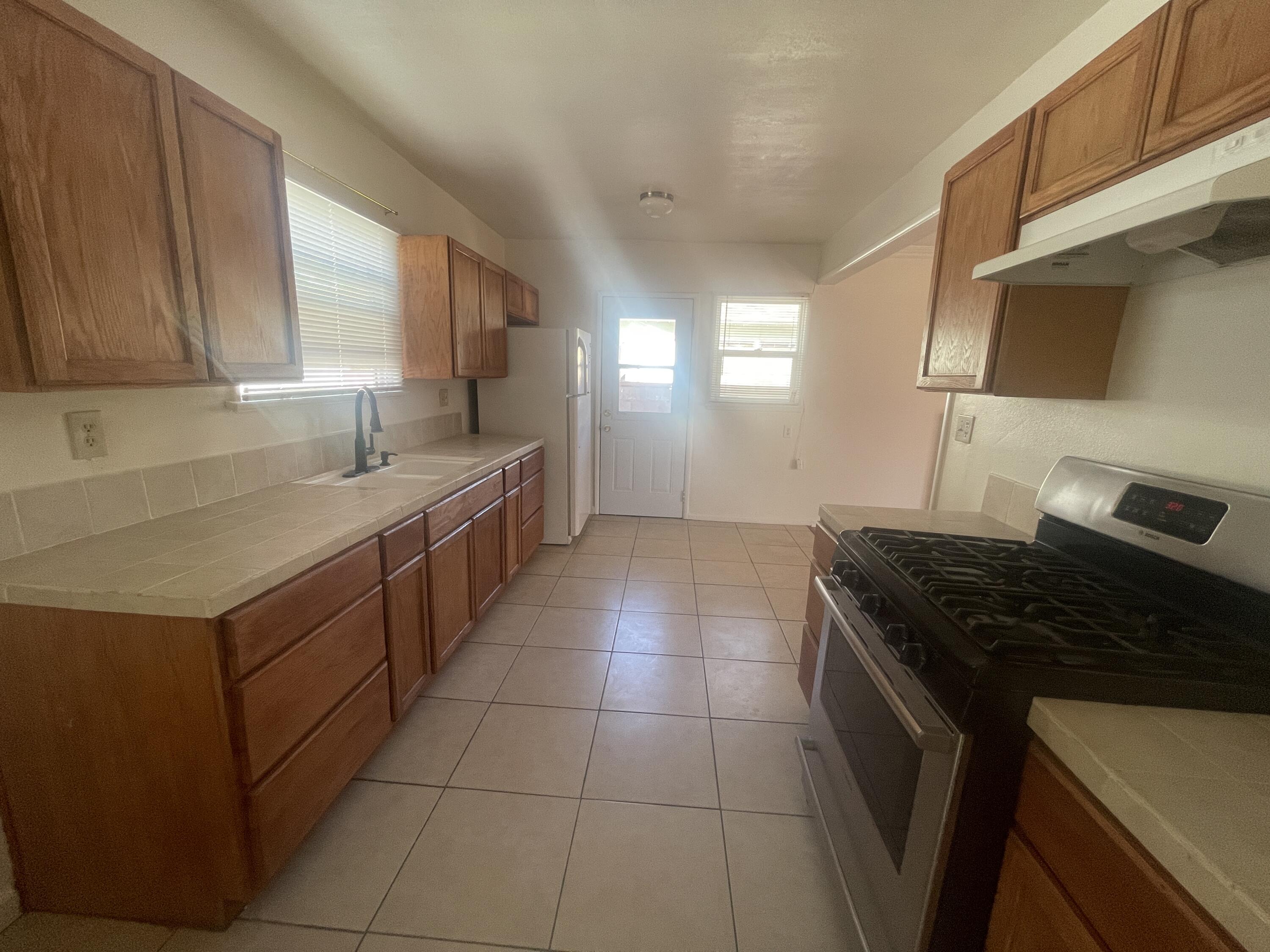 1372 Jenner Street Lancaster, CA 93534 - Photo 2 of 16 a kitchen with a sink a stove and a microwave