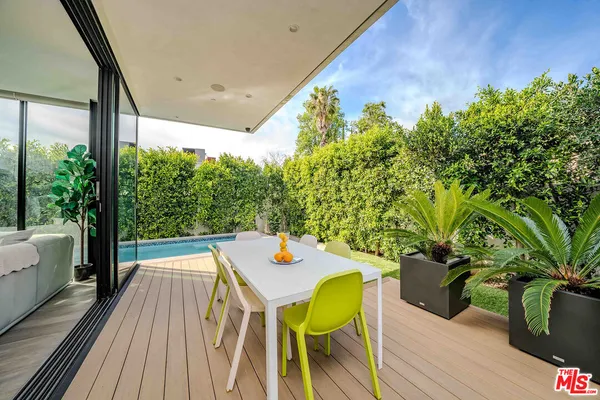a view of a patio with table and chairs under an umbrella