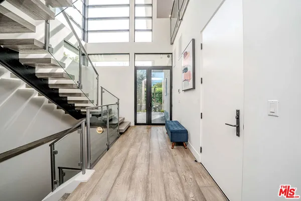 a bedroom with a bed a desk and chair with wooden floor