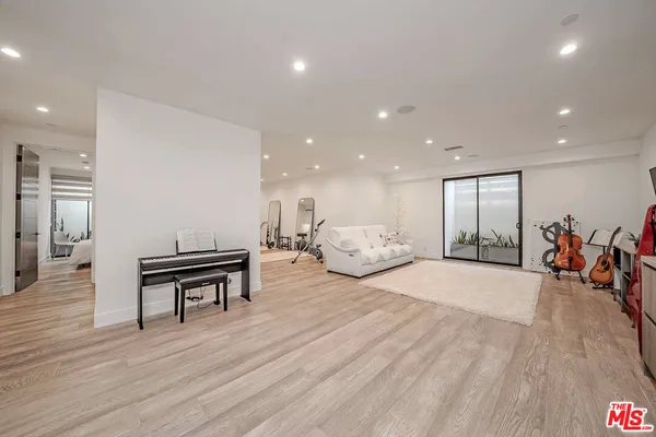 a living room with furniture gym equipment and a large window