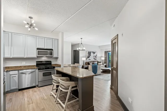 a large kitchen with a table chairs refrigerator and cabinets