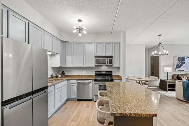a kitchen with stainless steel appliances granite countertop a sink stove and refrigerator