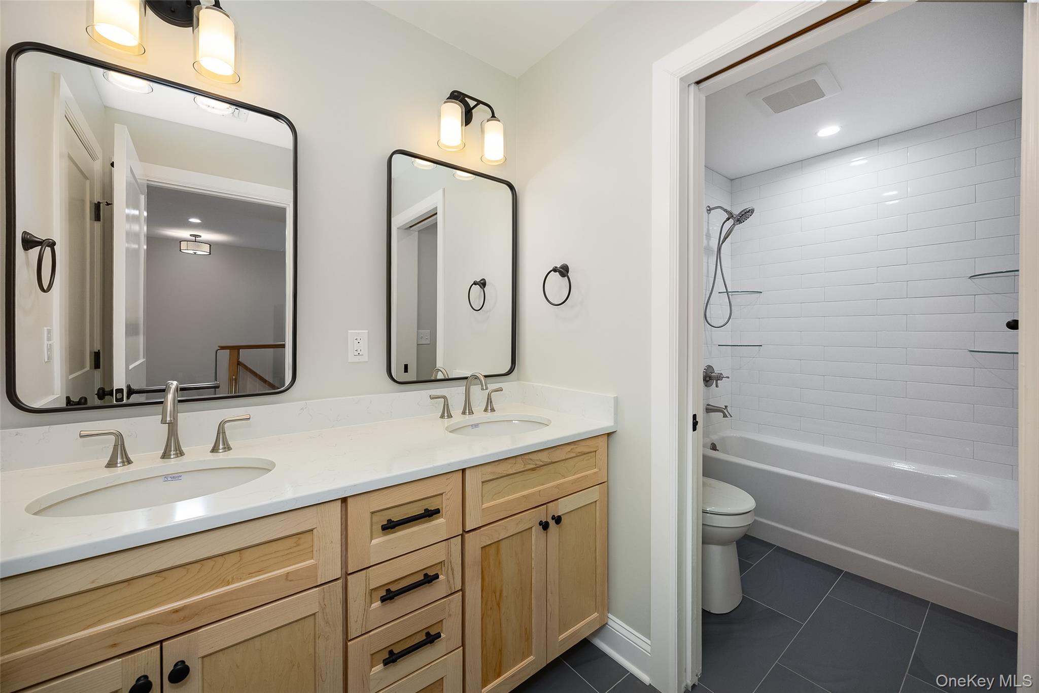 19 Henry Street, Unit 4 Beacon, NY 12508 - Photo 14 of 26 a bathroom with a granite countertop sink a toilet a large mirror a bathtub and shower