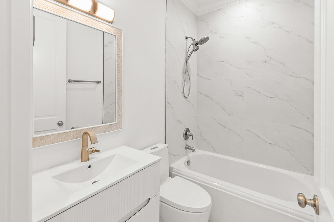 47 Southwest Osceola Street, Unit 206 Stuart, FL 34994 - Photo 20 of 47 a bathroom with a white bath tub sitting next to a white sink and a white door