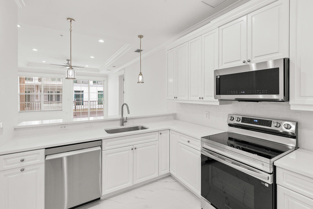 47 Southwest Osceola Street, Unit 206 Stuart, FL 34994 - Photo 8 of 47 a kitchen with a sink stove and microwave