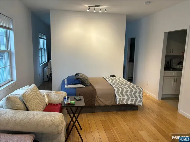 a bedroom with a bed and wooden floor