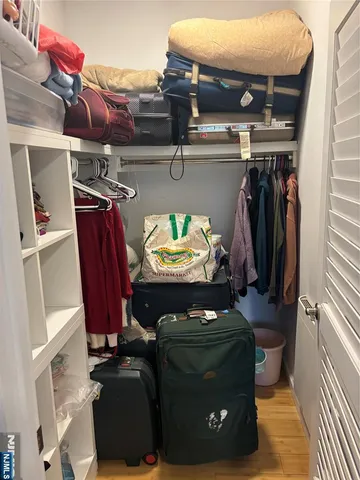 a view of walk in closet with clothes and shoes