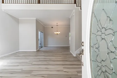 a view of a hallway with wooden floor and entryway
