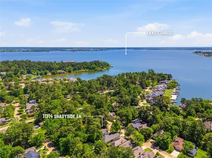 an aerial view of a house with a yard and lake view