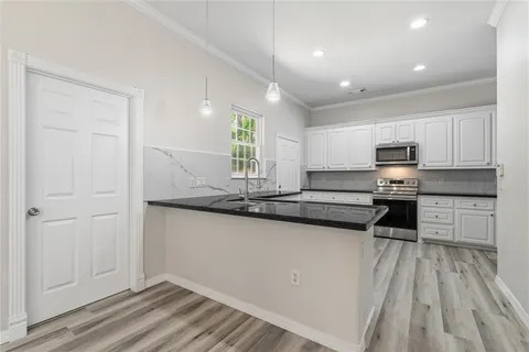 a kitchen with granite countertop white cabinets and stainless steel appliances