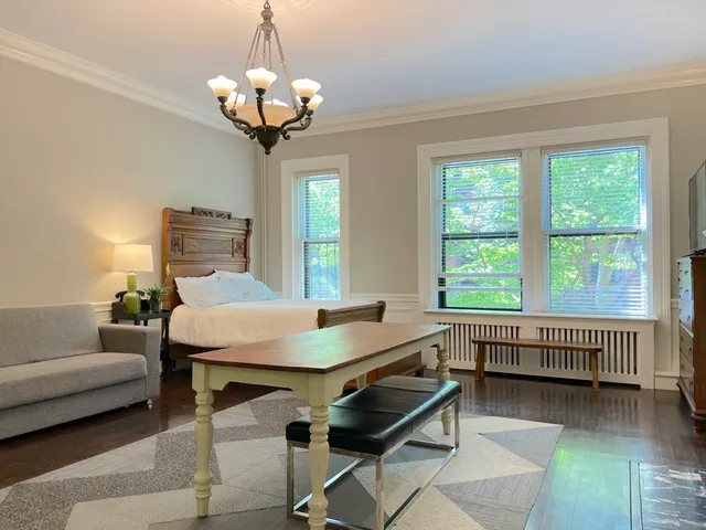 a living room with furniture a chandelier and a window