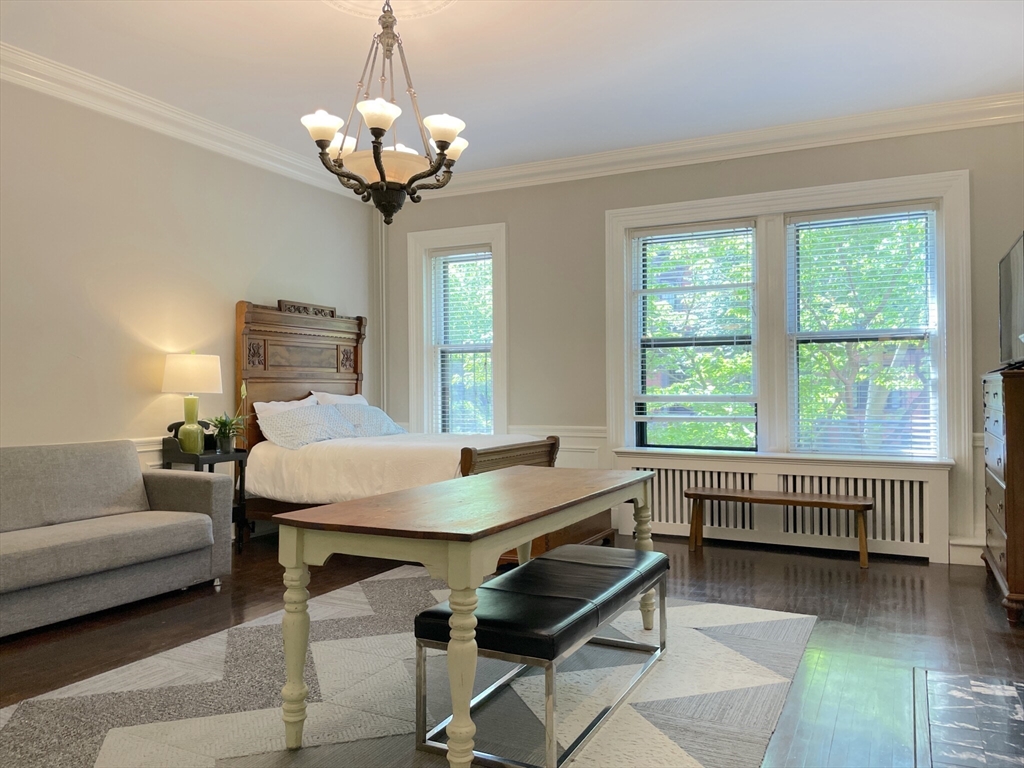 a living room with furniture a chandelier and a window