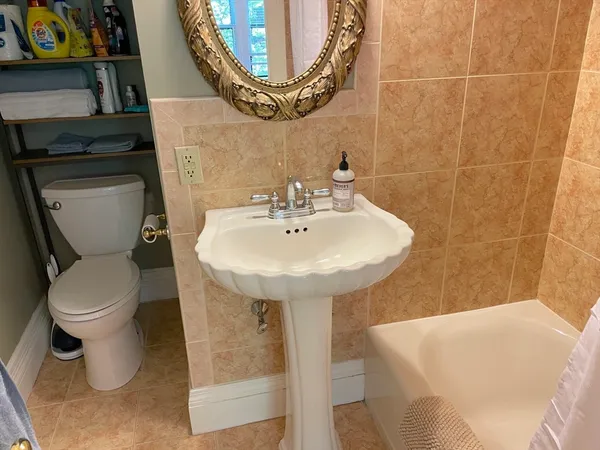 a bathroom with a sink a toilet and a mirror