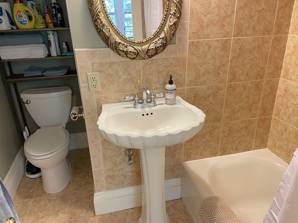 164 Beacon Street, Unit 1 Boston, MA 02116 - Photo 11 of 12 a bathroom with a sink a toilet and a mirror