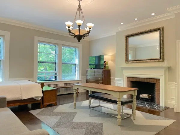 a living room with furniture a chandelier and a fireplace