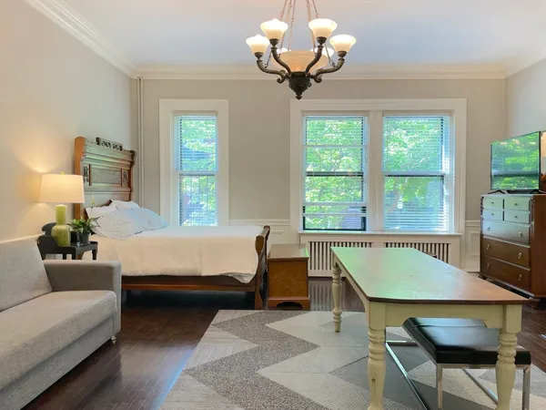 a bedroom with a bed and a chandelier