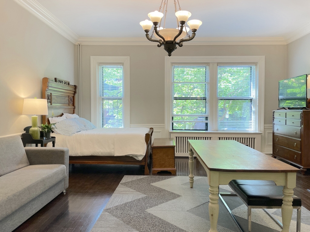 164 Beacon Street, Unit 1 Boston, MA 02116 - Photo 3 of 12 a bedroom with a bed and a chandelier