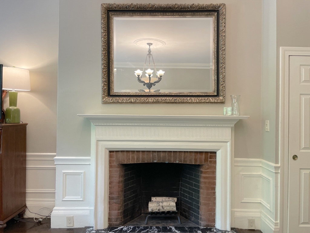 164 Beacon Street, Unit 1 Boston, MA 02116 - Photo 4 of 12 a living room with a fireplace and a wooden floor