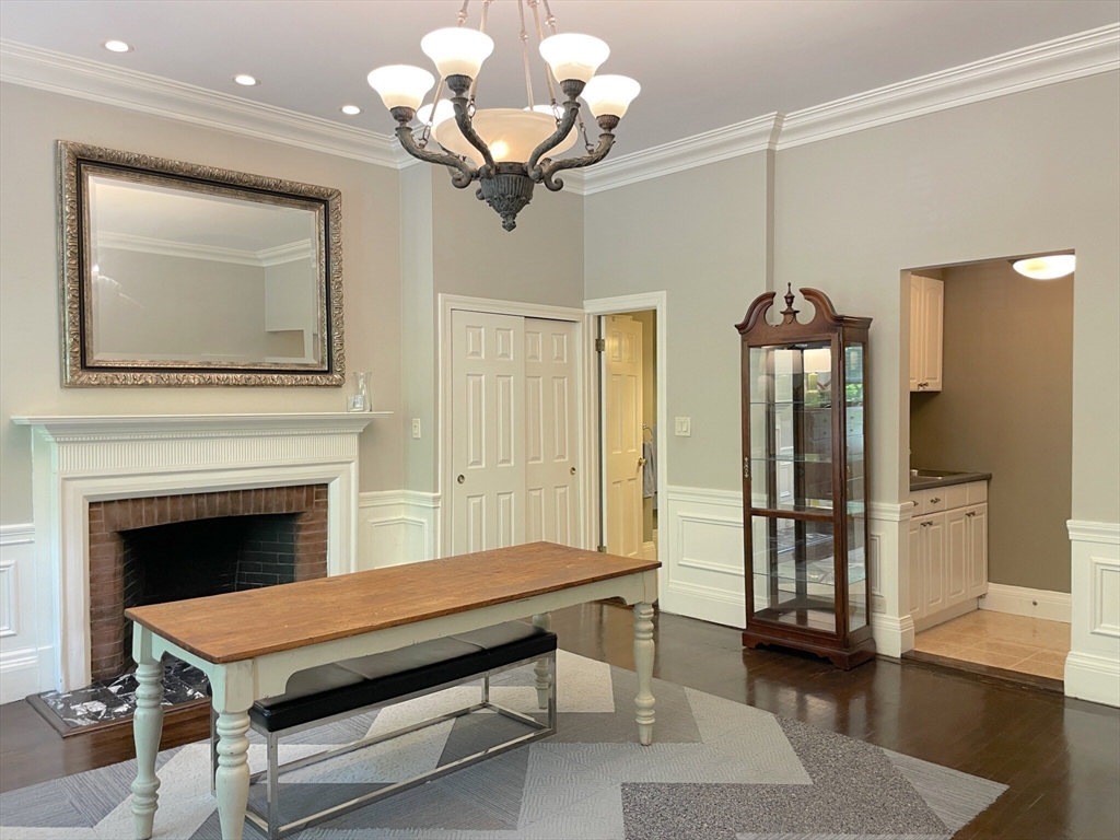 164 Beacon Street, Unit 1 Boston, MA 02116 - Photo 5 of 12 a living room with furniture a chandelier and a fireplace