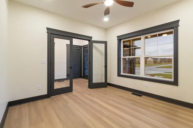 a view of an empty room with a window and a kitchen