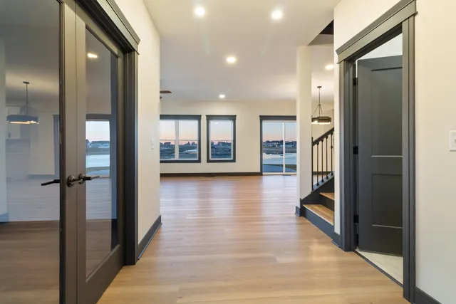 a view of a hallway with wooden floor and a living room