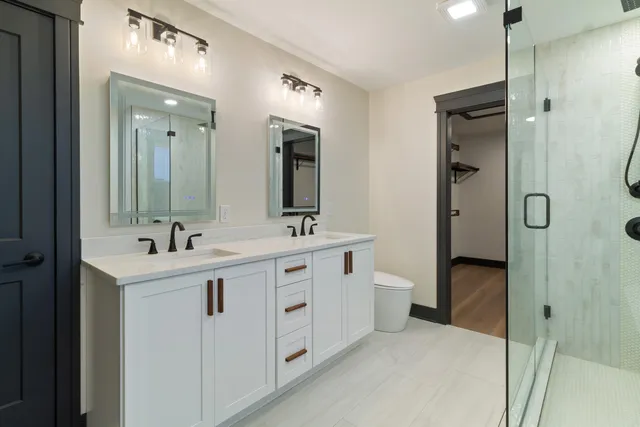 a bathroom with a double vanity sink mirror and shower