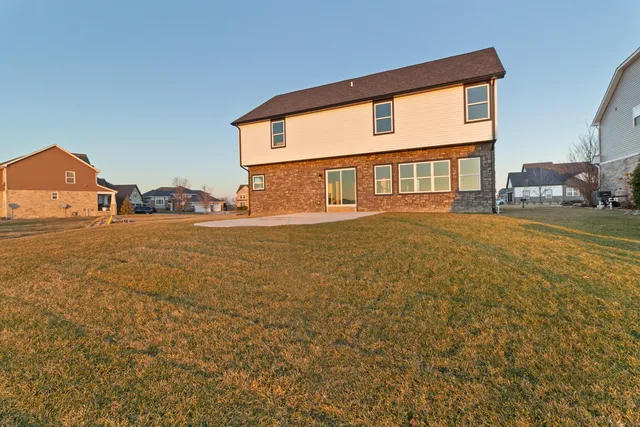 a view of a house with backyard and sitting area