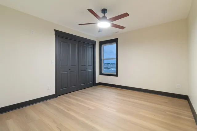 an empty room with closet and fan