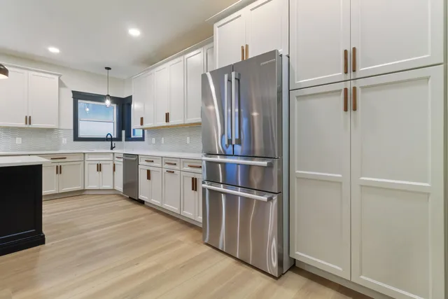 a kitchen with stainless steel appliances granite countertop a refrigerator and a stove top oven