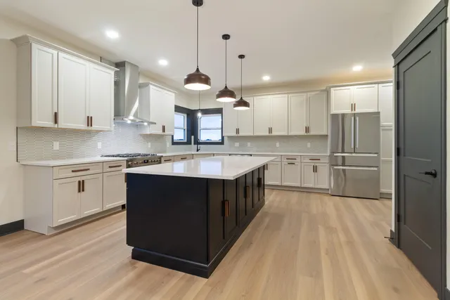 a kitchen with kitchen island granite countertop a sink appliances cabinets and a counter top space