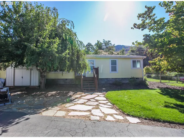 a front view of a house with a yard and trees