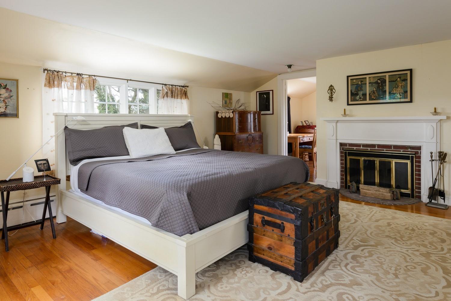 115 Rendezvous Lane Barnstable, MA 02630 - Photo 24 of 34 a spacious bedroom with a bed and a fireplace