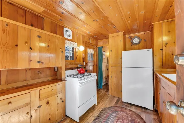 a kitchen with a refrigerator a sink and dishwasher with wooden floor