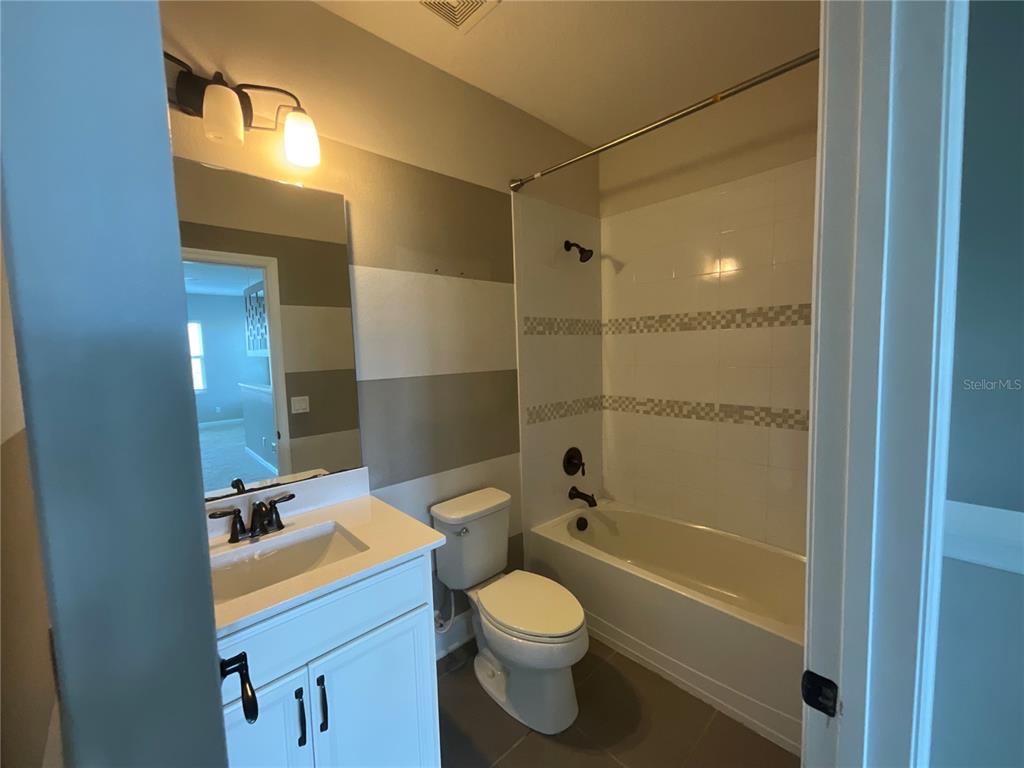 3560 Pixie Lane St. Cloud, FL 34772 - Photo 18 of 74 a bathroom with a sink a toilet and shower