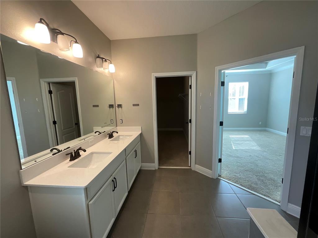 3560 Pixie Lane St. Cloud, FL 34772 - Photo 28 of 74 a bathroom with a double vanity sink and mirror