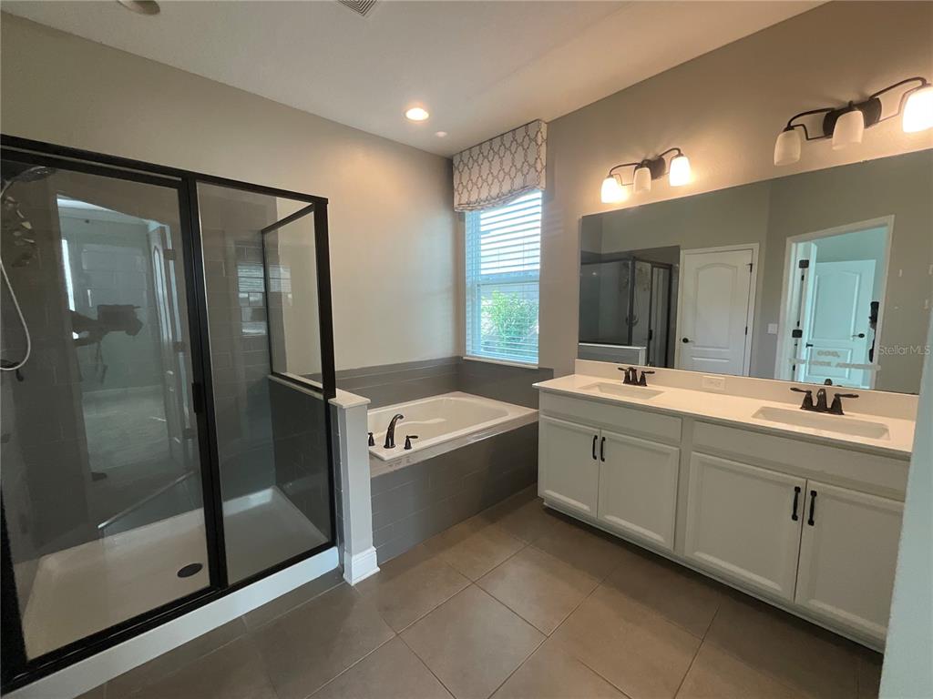 3560 Pixie Lane St. Cloud, FL 34772 - Photo 34 of 74 a spacious bathroom with a tub sink shower and mirror