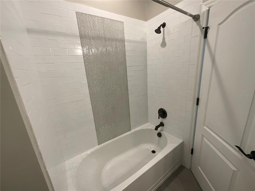 3560 Pixie Lane St. Cloud, FL 34772 - Photo 53 of 74 a bathroom with a tub and a shower