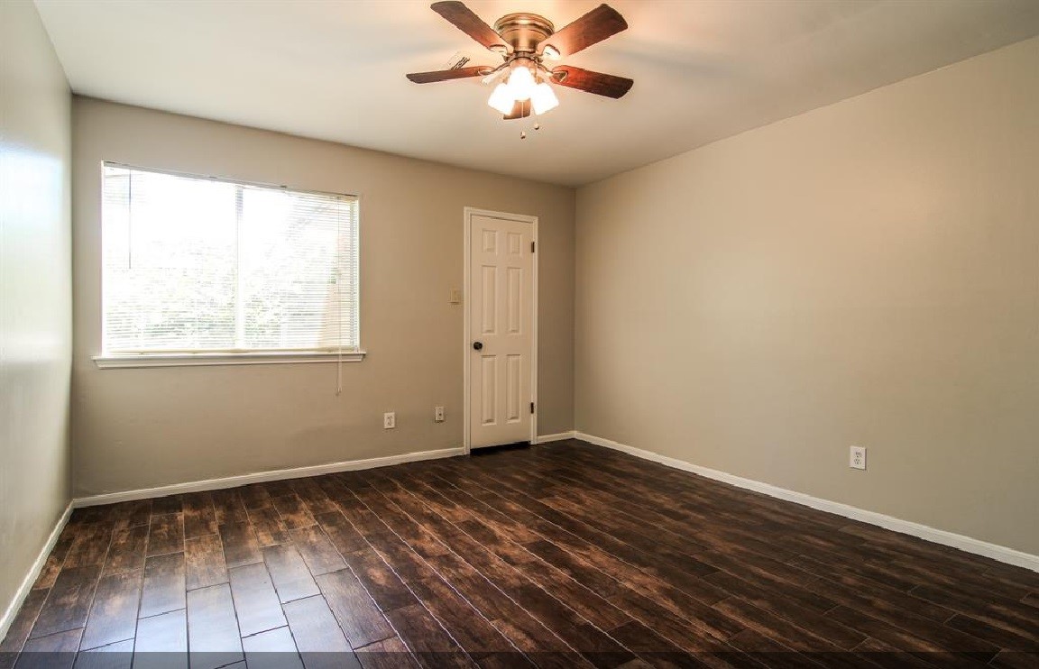 11423 Wickersham Lane Houston, TX 77077 - Photo 17 of 39 a view of an empty room with wooden floor and a window