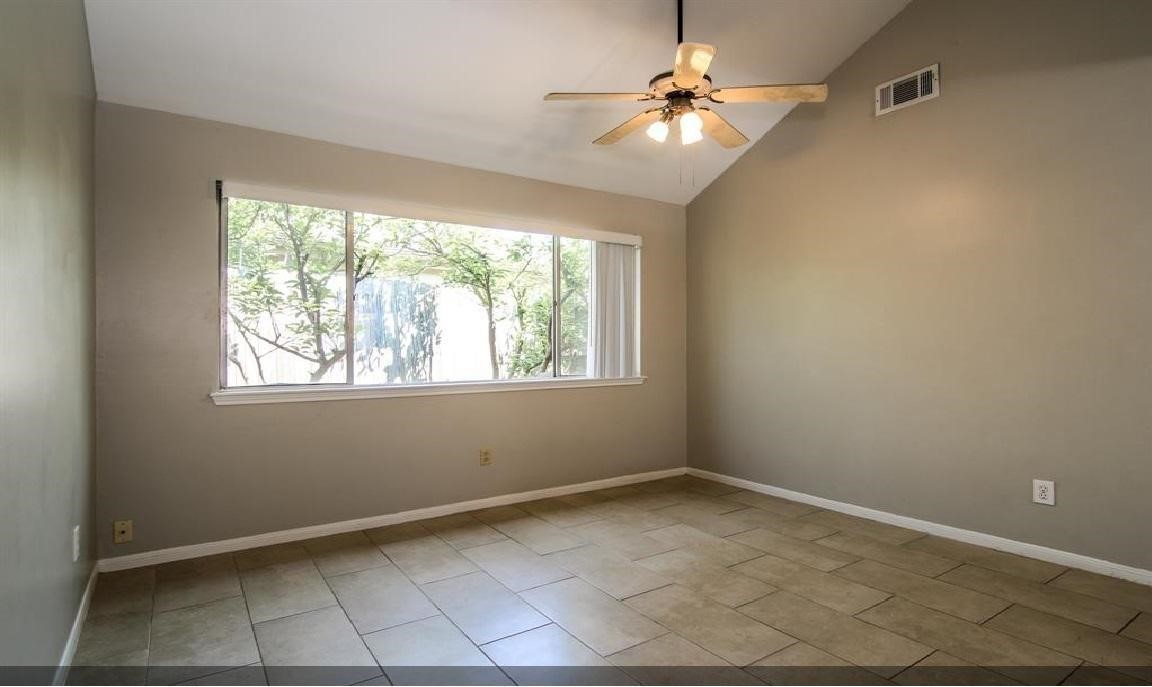 11423 Wickersham Lane Houston, TX 77077 - Photo 19 of 39 an empty room with windows and fan