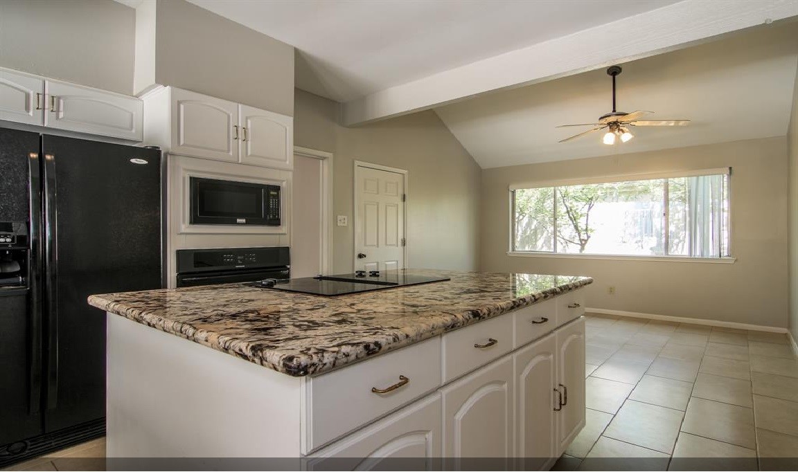 11423 Wickersham Lane Houston, TX 77077 - Photo 7 of 39 a kitchen with kitchen island granite countertop a sink cabinets and stainless steel appliances