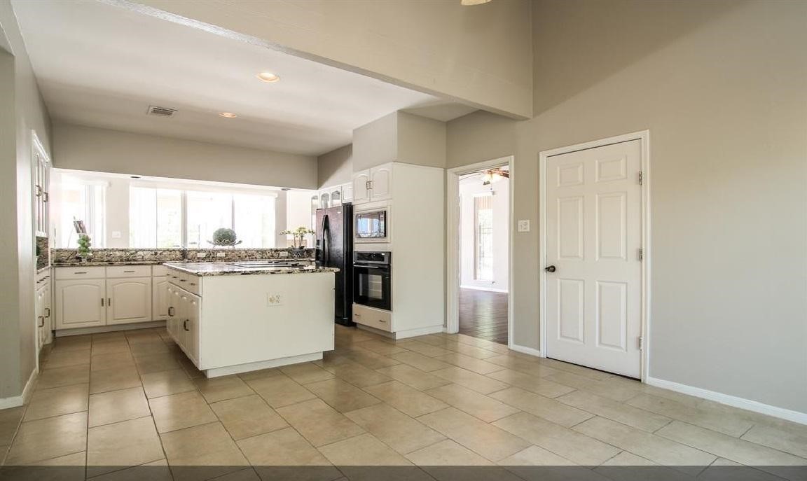 11423 Wickersham Lane Houston, TX 77077 - Photo 10 of 39 a kitchen with a refrigerator and white cabinets