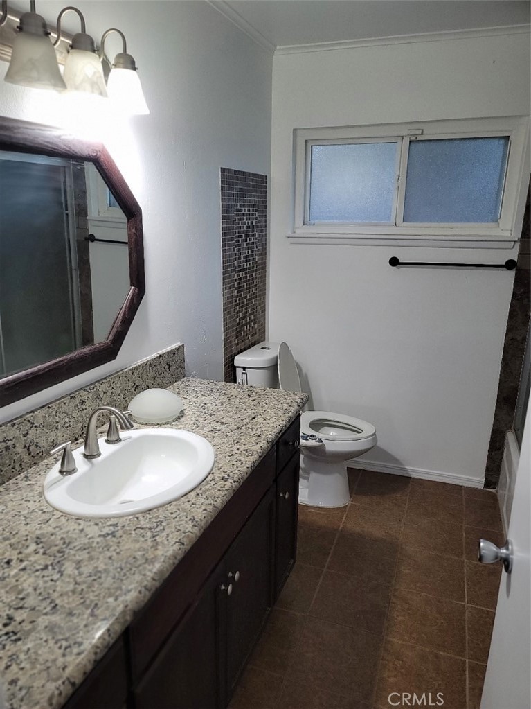 6984 Center Street Highland, CA 92346 - Photo 14 of 24 a bathroom with a granite countertop sink a toilet and a mirror