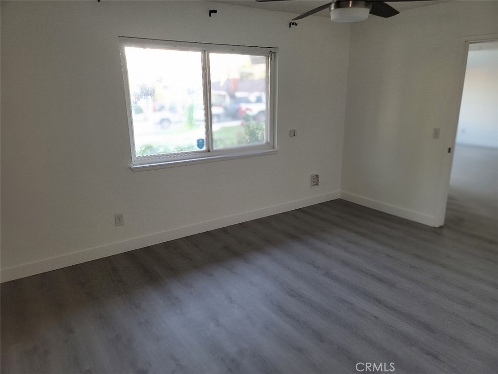 6984 Center Street Highland, CA 92346 - Photo 7 of 24 an empty room with wooden floor and windows
