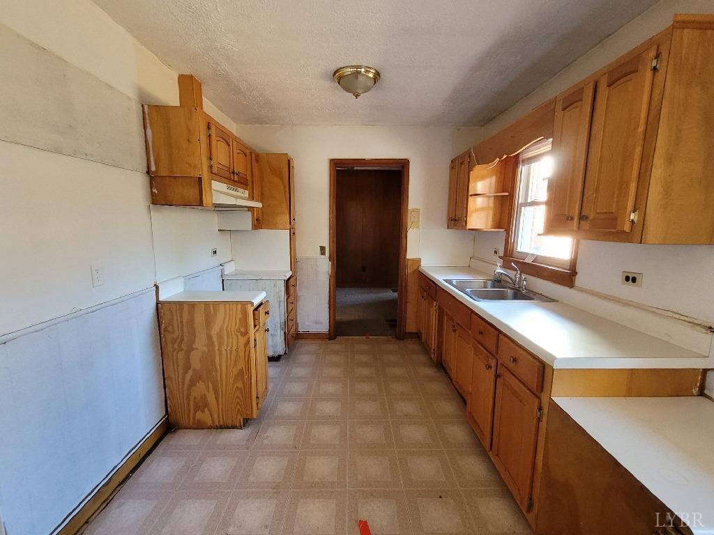 1025 Country Club Road Hurt, VA 24563 - Photo 7 of 15 a kitchen with stainless steel appliances a sink a stove a refrigerator cabinets and a window