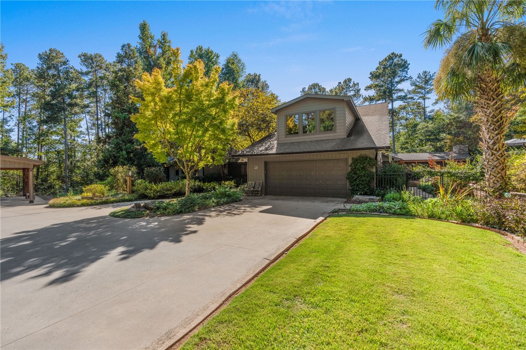 604 Ridgecrest Drive Clemson, SC 29631 - Photo 5 of 50 Mature trees frame a wide concrete driveway leading to the integrated two-car garage.