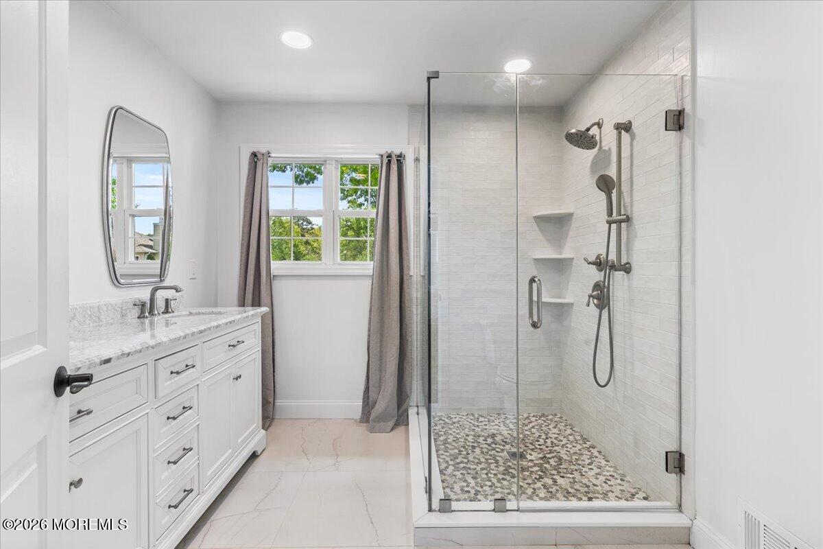 49 Diamond Lane Howell, NJ 07731 - Photo 22 of 46 a bathroom with a granite countertop sink a shower a mirror and a bathtub
