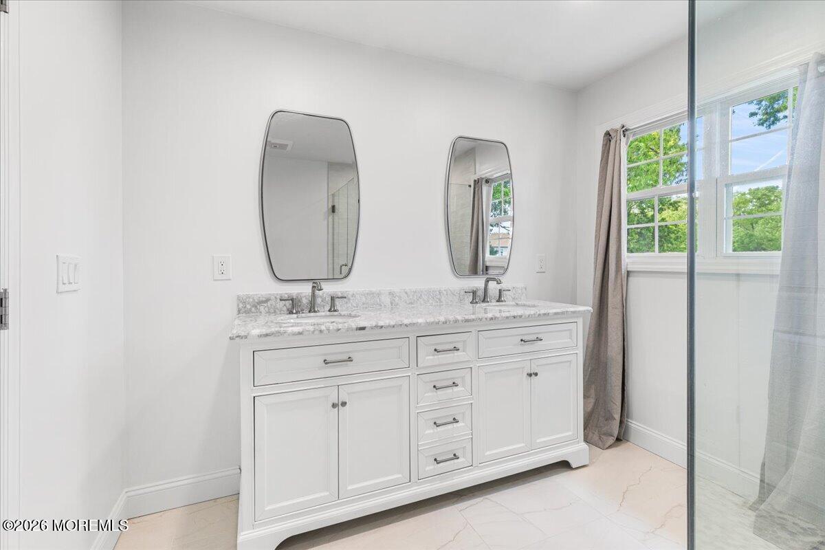 49 Diamond Lane Howell, NJ 07731 - Photo 23 of 46 a bathroom with double vanity sink a two mirror a window and glass door