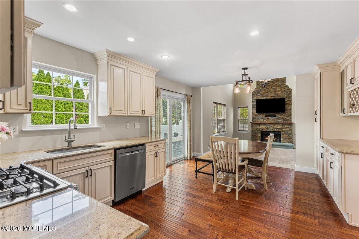 49 Diamond Lane Howell, NJ 07731 - Photo 10 of 46 a kitchen with stainless steel appliances granite countertop a stove top oven a sink dishwasher a dining table and chairs with wooden floor