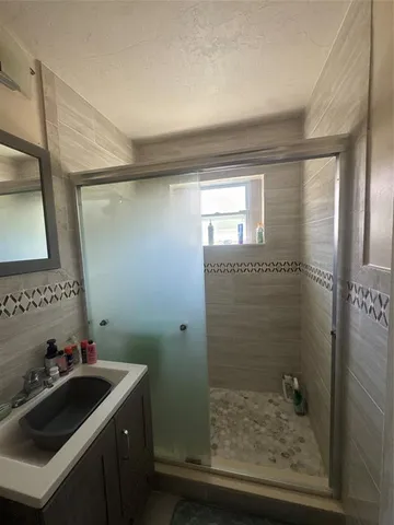 a bathroom with a sink a mirror and shower