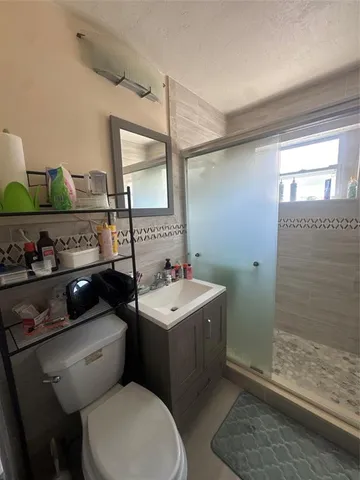 a bathroom with a sink toilet and shower